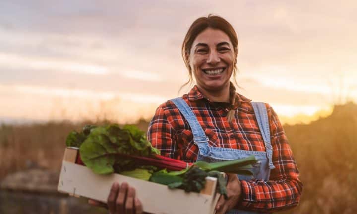 Farmer smiling with harvested vegetables