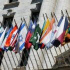 Flags of many nations hang outside of a UN headquarters building.